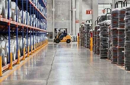 Warehouse floor with a forklift moving stock between pallet racking